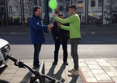 Mann überreicht Mann ein Luftballon und eine Topfblume
